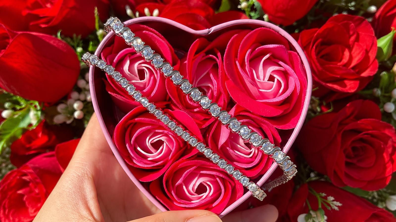 Heart-shaped jewelry box with two tennis bracelets displayed on top, showcasing affordable luxury jewelry.