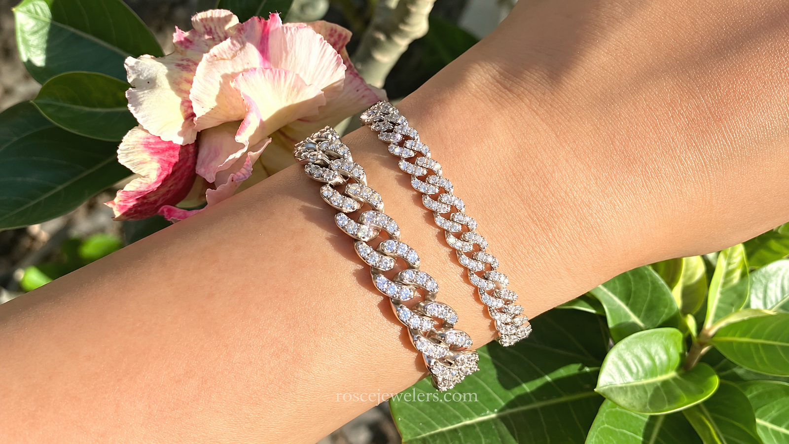 Wrist wearing large and small Cuban tennis bracelets, showcasing affordable luxury jewelry with a bold, layered look.