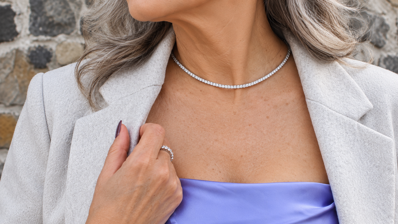 Grandmother wearing a tennis bracelet, tennis necklace, and diamond ring, showcasing affordable luxury jewelry with timeless elegance.