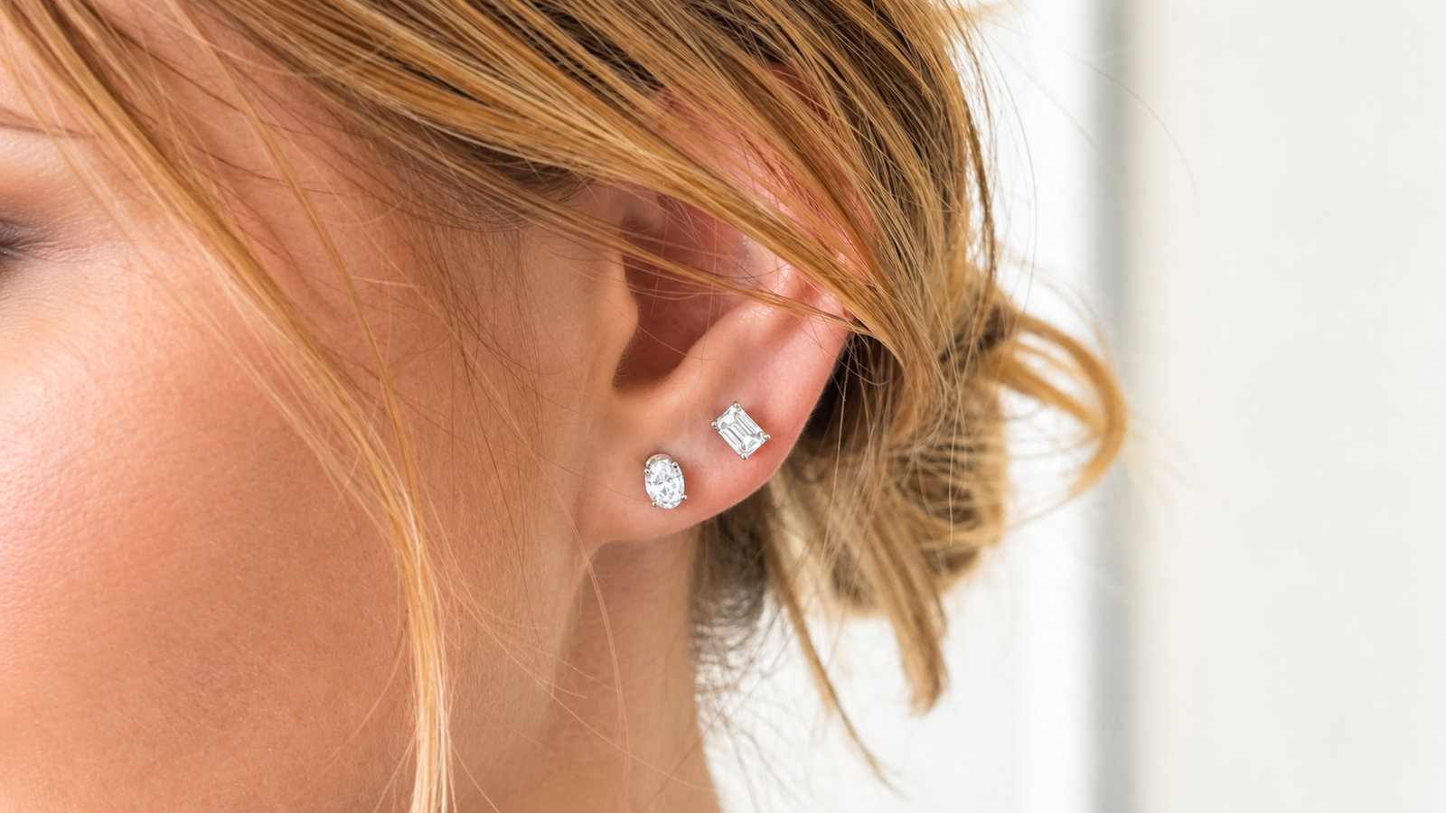 Close-up of a woman’s ear wearing a variety of diamond earring sets, showcasing affordable luxury jewelry for everyday elegance.